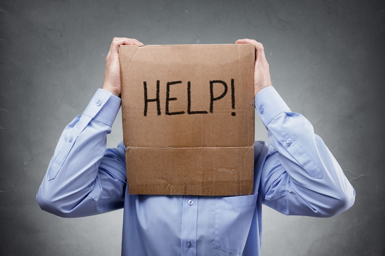 Cardboard box on businessman head asks for help concept for problems, support, overworked or stress