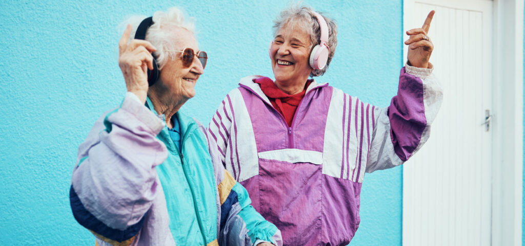 Music, dance and senior women with fashion in city, happy together and streaming on headphones. Retirement, happiness and elderly friends dancing to hip hop audio for fun, freedom and urban style