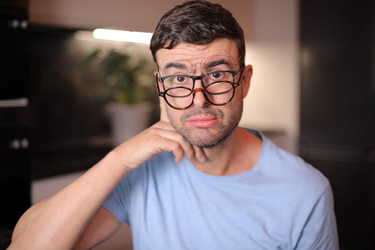 A comedic man in his early forties is wearing three prescription eyeglasses simultaneously. He has several eye conditions and every single on of them works for a certain situation.